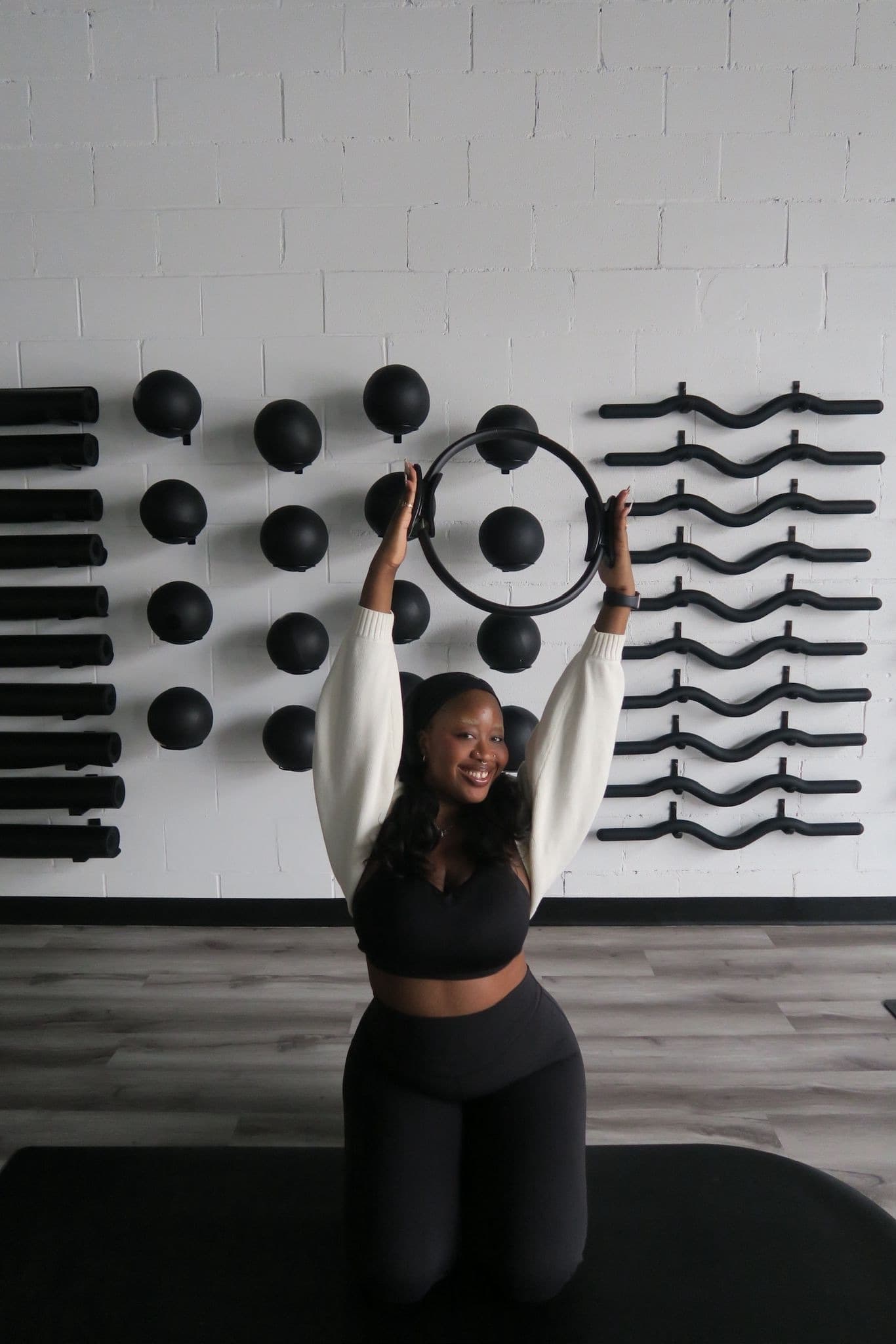 Member in the studio holding a Pilates ring